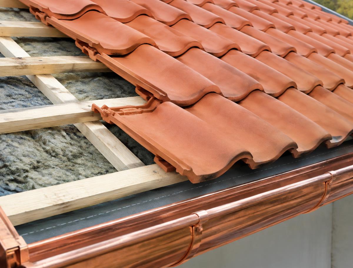 Posa di tegole su listelli in legno sopra lo strato di isolamento, con grondaia in rame